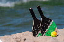 Rackets and ball on the sandy beach  Summer sport concept
