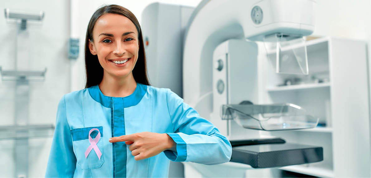 International symbol for October Breast Cancer Awareness Month. Female doctor with pink awareness ribbon standing near mammography machine. Health care and medical women concept.