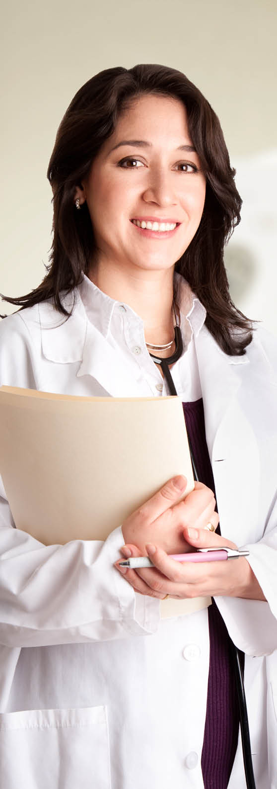 Beautiful happy female doctor physician radiologist holding patient medical chart and pen standing in CT CAT Scan room at hospital, isolated.