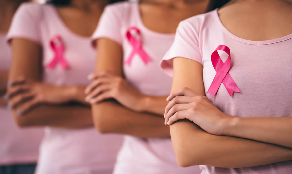 Cropped image of group of young multiracial woman with pink ribbons are struggling against breast cancer. Breast cancer awareness concept.