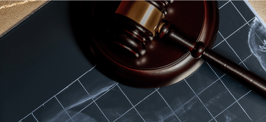 An X-ray under a wooden gavel, suggesting legal issues related to medical procedures or health