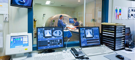 MRI machine and screens with doctor and nurse