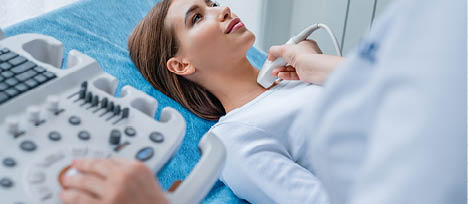Woman getting her neck examined by doctor using ultrasound scanner at modern clinic